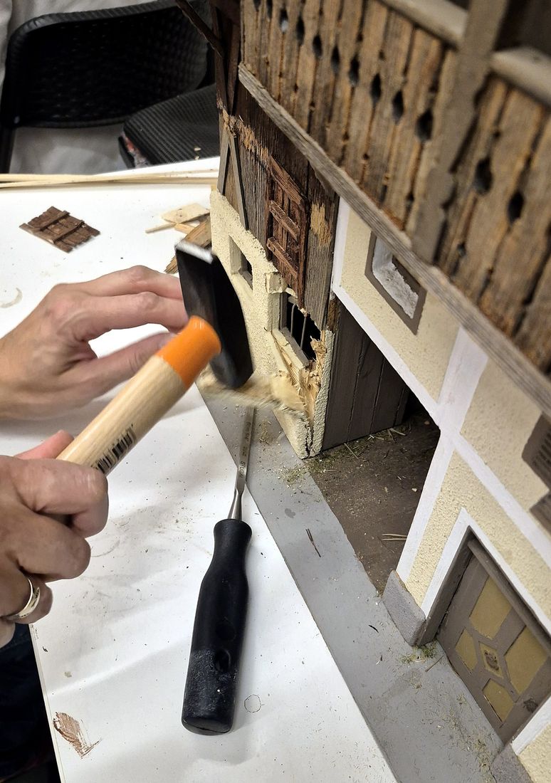 Beschädigte Stellen an der Hauswand werden vorsichtig ausgestemmt und ausgebessert