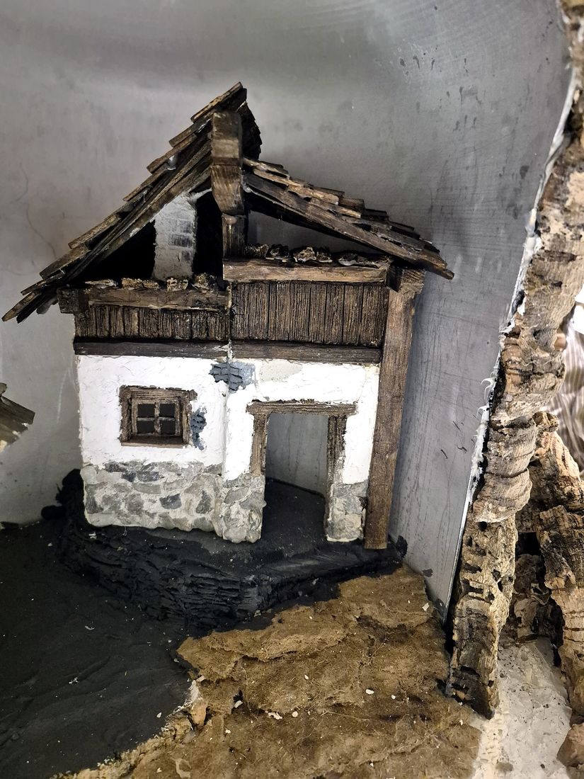 Das Haupthaus im Rohbau mit Steinsockel und Holzdach
